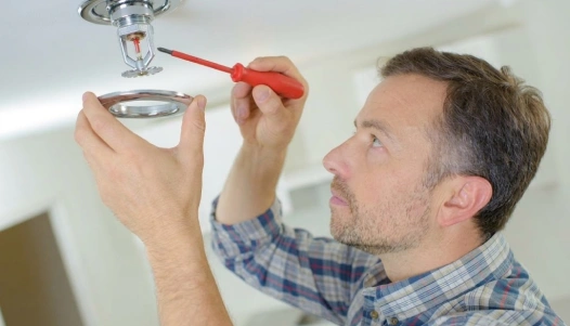 Technician inspecting an apartment fire sprinkler system
